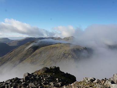 A mountain landscape with rocky peaks and clouds at Caldhu Cottage in Holmrook
