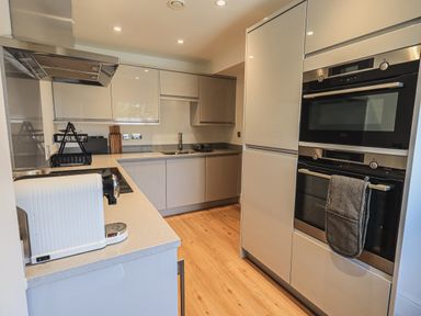 A kitchen with countertop appliances cabinets a double oven and wooden floor at The Mabel Suite Stone Cross Mansion in Ulverston