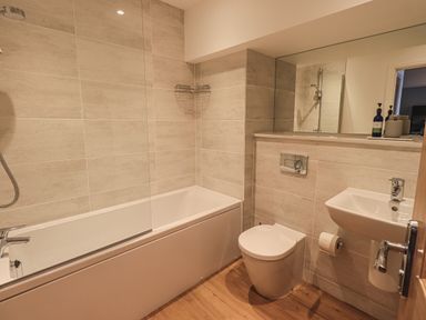 A bathroom with a bathtub shower toilet and sink with a mirror at The Mabel Suite Stone Cross Mansion in Ulverston