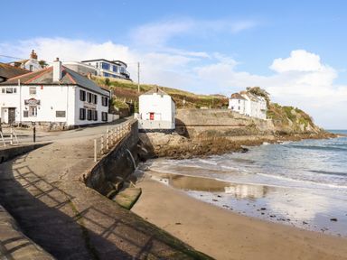 A coastal area with white buildings near a beach at EdyVean in Portmellon near Mevagissey