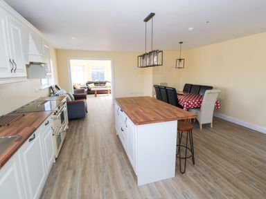 A kitchen with an island and dining area at Tí Tom Nárta, Trabane near Lettermore, County Galway