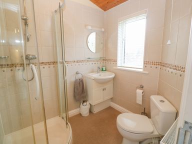 A bathroom with a shower cubicle sink toilet and window at Lodge 23 in Torpoint