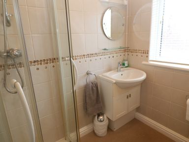 A bathroom with a shower enclosure sink with cabinet mirror and window at Lodge 23 in Torpoint