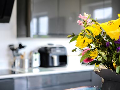 A kitchen countertop with a bouquet of flowers and kitchen appliances at Lowenda in Polzeath