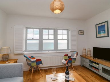 A living room with two patchwork chairs and ocean view at Beach Retreat in Weymouth