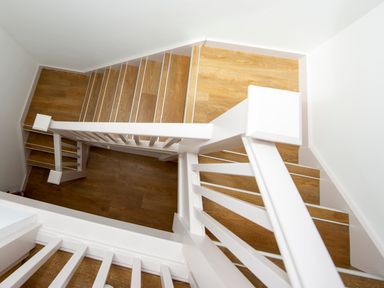 A wooden staircase with white railings and walls at Starling Lodge in Wedmore
