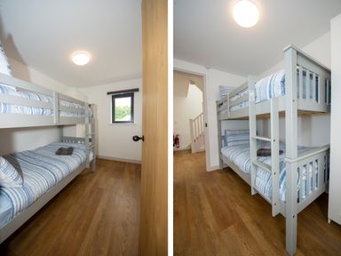 A bedroom with a gray bunk bed and wooden floor at Starling Lodge in Wedmore