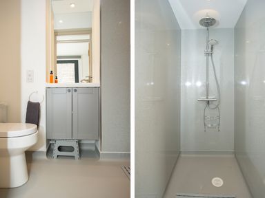A bathroom with a toilet sink cabinet and a shower area at Starling Lodge in Wedmore