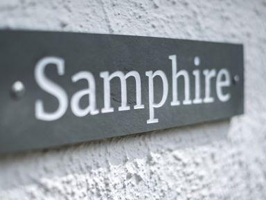 A close up of a sign with the text Samphire on a textured wall at Samphire in Rock