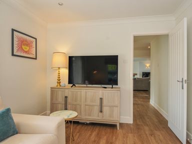 A living room with a television and lamp at Samphire in Rock