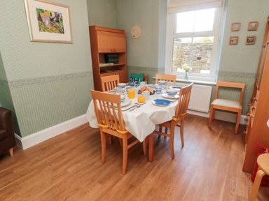 A dining room with a table set for breakfast near a window at 19 Duke Street in Alnwick