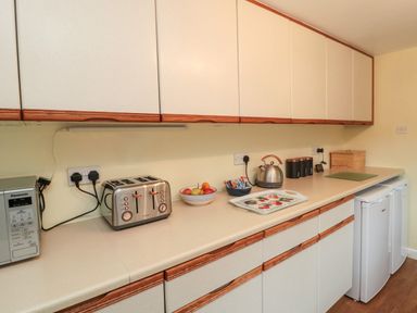 A kitchen countertop with microwave toaster kettle fruit bowl and storage containers at 19 Duke Street in Alnwick