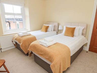 A bedroom with two single beds each with white linens and brown blankets and pillows at 19 Duke Street in Alnwick