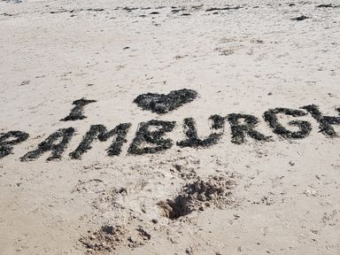A message written with seaweed on sand that reads i love ramelurgan at a beach