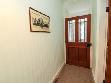 A hallway with a framed picture on the wall and a wooden door with glass panels at 19 Duke Street in Alnwick