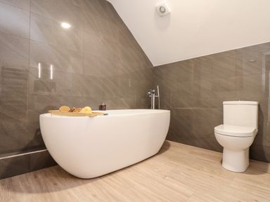 A bathroom with a bathtub and a toilet at Penthouse 23 in Newquay