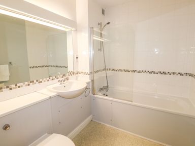 A bathroom with a bathtub shower combination a sink and a mirror at Tilly Mint Cottage Nr Ullswater