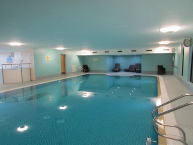 An indoor swimming pool with lounge chairs around at Tilly Mint Cottage Nr Ullswater