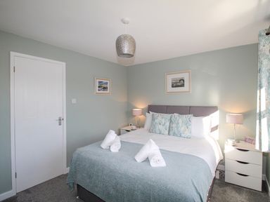 A bedroom with a double bed and two bedside tables with lamps at Chesil Retreat in Weymouth