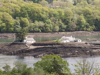 A small island with houses surrounded by water and trees at The Annexe in Llanfairpwllgwyngyll