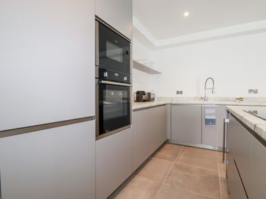 A kitchen with built-in oven microwave a sink and countertop appliances at 30 Cliff Edge in Newquay