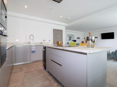 A kitchen with an island countertop a champagne bucket and a gold bowl at 30 Cliff Edge in Newquay