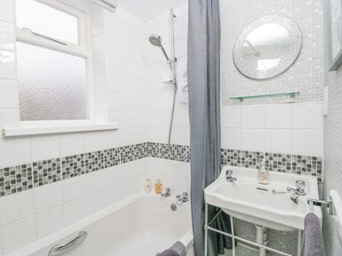 A bathroom with a bathtub shower curtain and sink at Nook Cottage Rosthwaite near Keswick