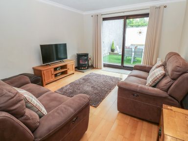 A living room with a television and sofa at Summerseat in Kirkby Stephen