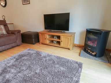 A living room with a television and fireplace at Summerseat in Kirkby Stephen