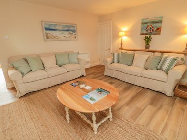 A living room with two beige sofas and a wooden coffee table at 46 Castle Street Norham