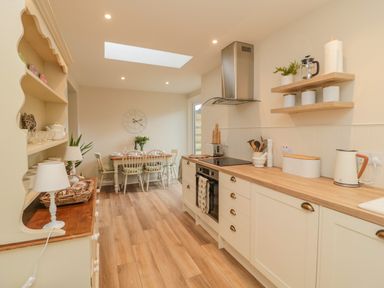 A kitchen with wooden countertops dining table with chairs and a skylight at 46 Castle Street in Norham