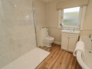 A bathroom with a shower, toilet, sink, and bathtub at 46 Castle Street in Norham