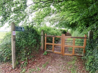 A public footpath with a wooden gate and green foliage at Quoit X Barn Stoodleigh near Bampton