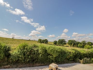 A view of fields with trees under a cloudy sky at Munderfield Mill in Munderfield near Bishops Frome