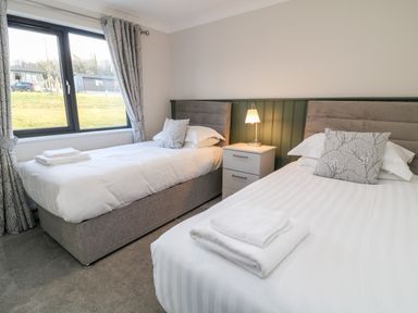 A bedroom with two single beds bedside table and lamp at Mayflower Broadwoodwidger near Ashwater