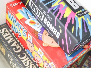 Stack of board games including Dan and Phils truth bombs what's up and classic family games