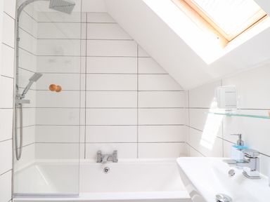 A bathroom with a bathtub shower sink and skylight at Penpoll in Little Petherick Creek near Padstow
