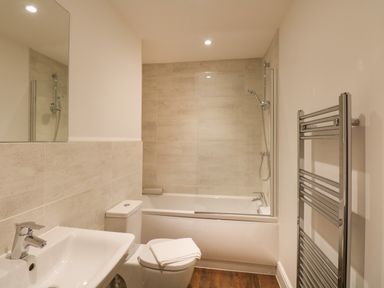 A bathroom with a sink toilet bathtub shower and towel rail at Alice House Stone Cross Mansion in Ulverston