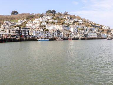 A coastal town with boats on the water and houses on a hillside at Smugglers Loft in Looe