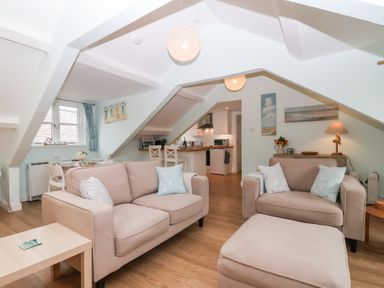 A living room with sofas and a dining area at Smugglers Loft in Looe