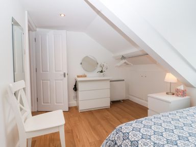 A bedroom with a bed and a mirror at Smugglers Loft in Looe