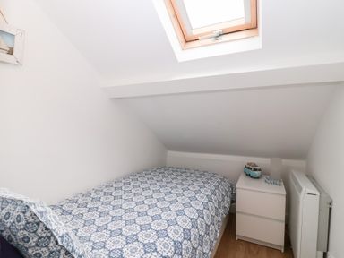 A bedroom with a bed and nightstand at Smugglers Loft in Looe
