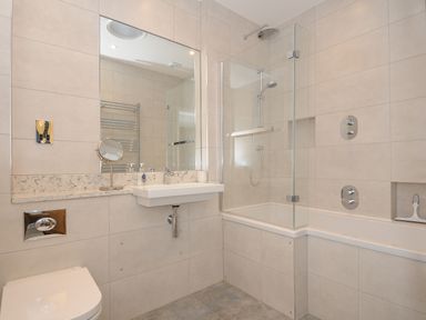 A bathroom with a bathtub shower combination sink and toilet at Sandsgate Lodge Spinster's Rock near Chagford