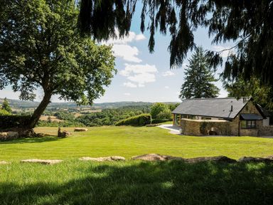 A countryside house with a stone wall near a large tree and grassy field at Sandsgate Lodge Spinster's Rock near Chagford