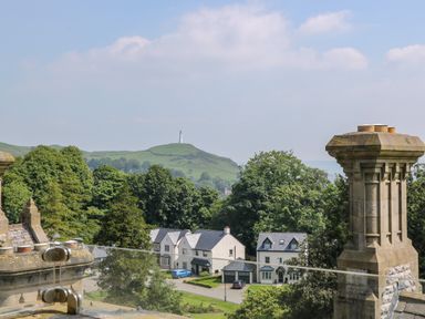 A view of houses trees and a hill with a monument in the distance at William Tower Suite Stone Cross Mansion in Ulverston