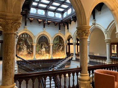 An interior space with arched columns stair railings and large wall murals at The Elizabeth Suite Stone Cross Mansion in Ulverston