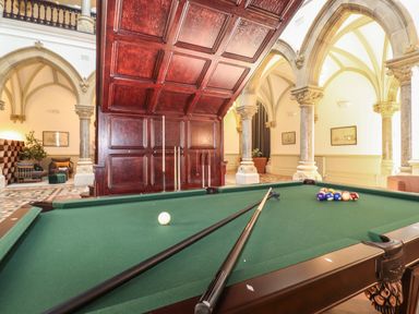 A billiard table with cues and balls in a room with arched columns and wooden paneling at The Elizabeth Suite Stone Cross Mansion Ulverston