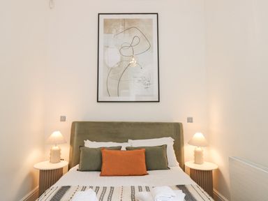 A bedroom with a bed pillows bedside tables lamps and abstract art on the wall at The Elizabeth Suite Stone Cross Mansion in Ulverston