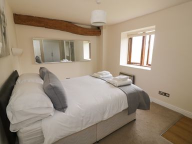 A bedroom with a bed pillows towels and a window at The Wheat House in Welford-On-Avon