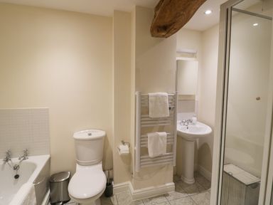 A bathroom with a toilet sink towel rail and bathtub at The Wheat House in Welford-On-Avon